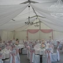 Esküvői sátor dekoráció textilekkel fehér szabott székuzattal púder rózsaszín szatén masnival