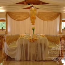 Esküvői teremdekoráció fehér lepel székszoknyával arany masnival