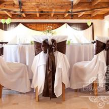 Esküvői teremdekoráció krém lepel székszékszoknyával barna masnival fényfüggöny háttér dekorációval