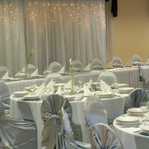 Esküvői textil dekoráció fényfüggönnyel ezüst szatén anyagában kötős székszoknyával